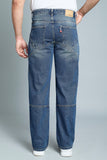 Person wearing blue jeans on a gray background