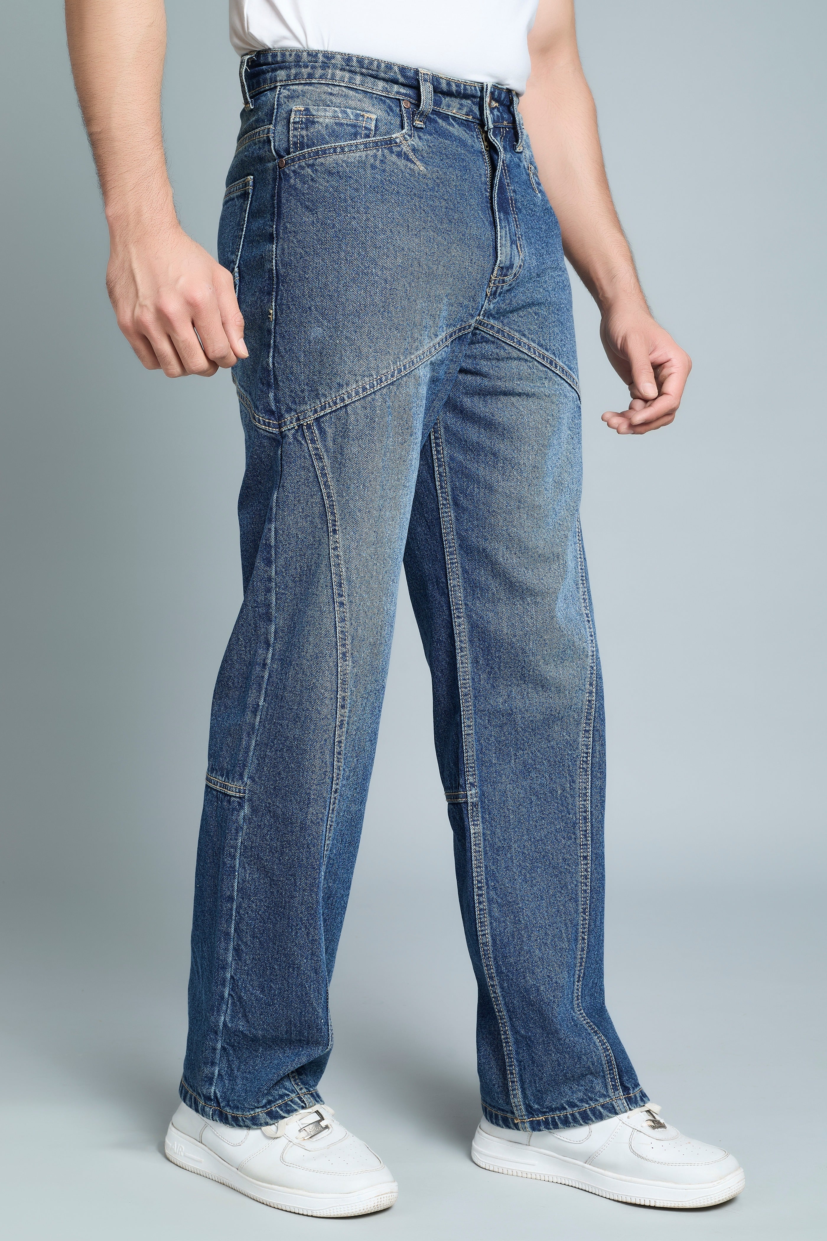 Person wearing blue jeans on a gray background