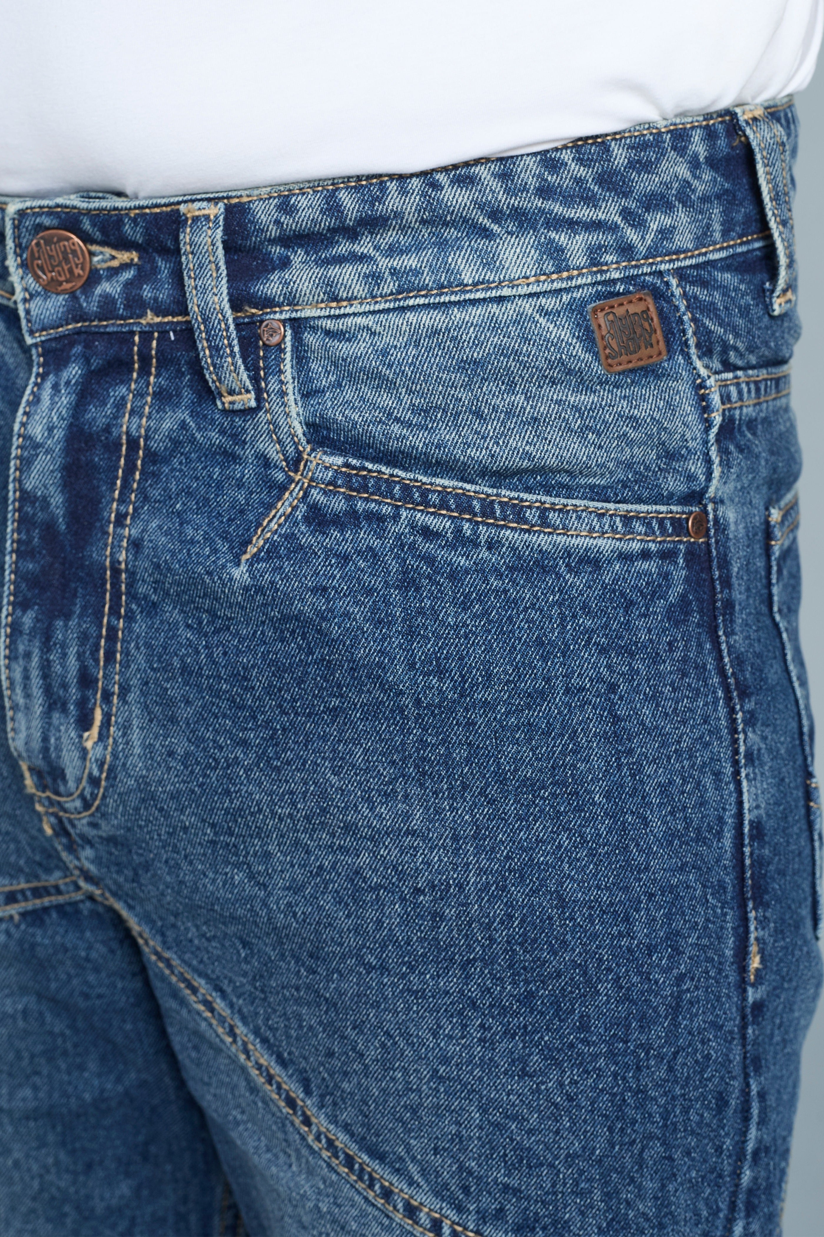 Close-up of blue jeans with brand logo on a gray background