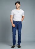 Man wearing a white t-shirt and blue jeans against a gray background