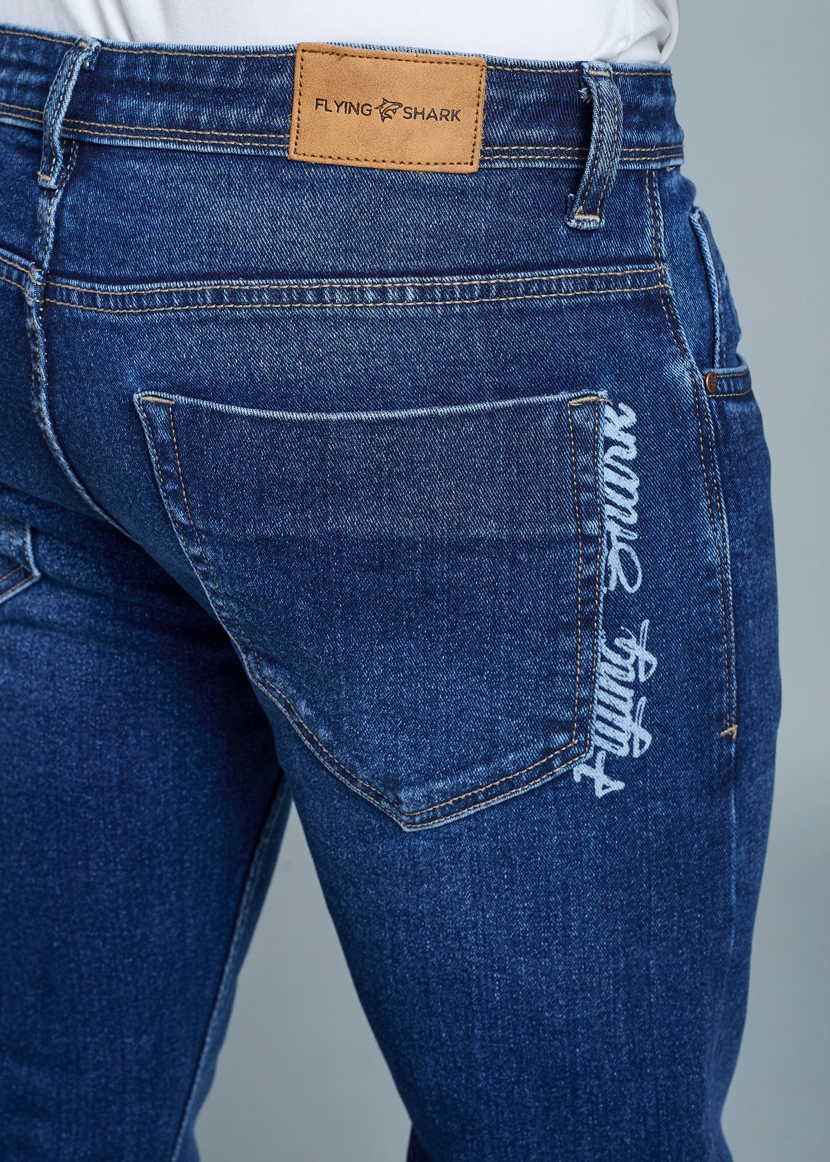 Blue jeans with a visible brand logo on a gray background