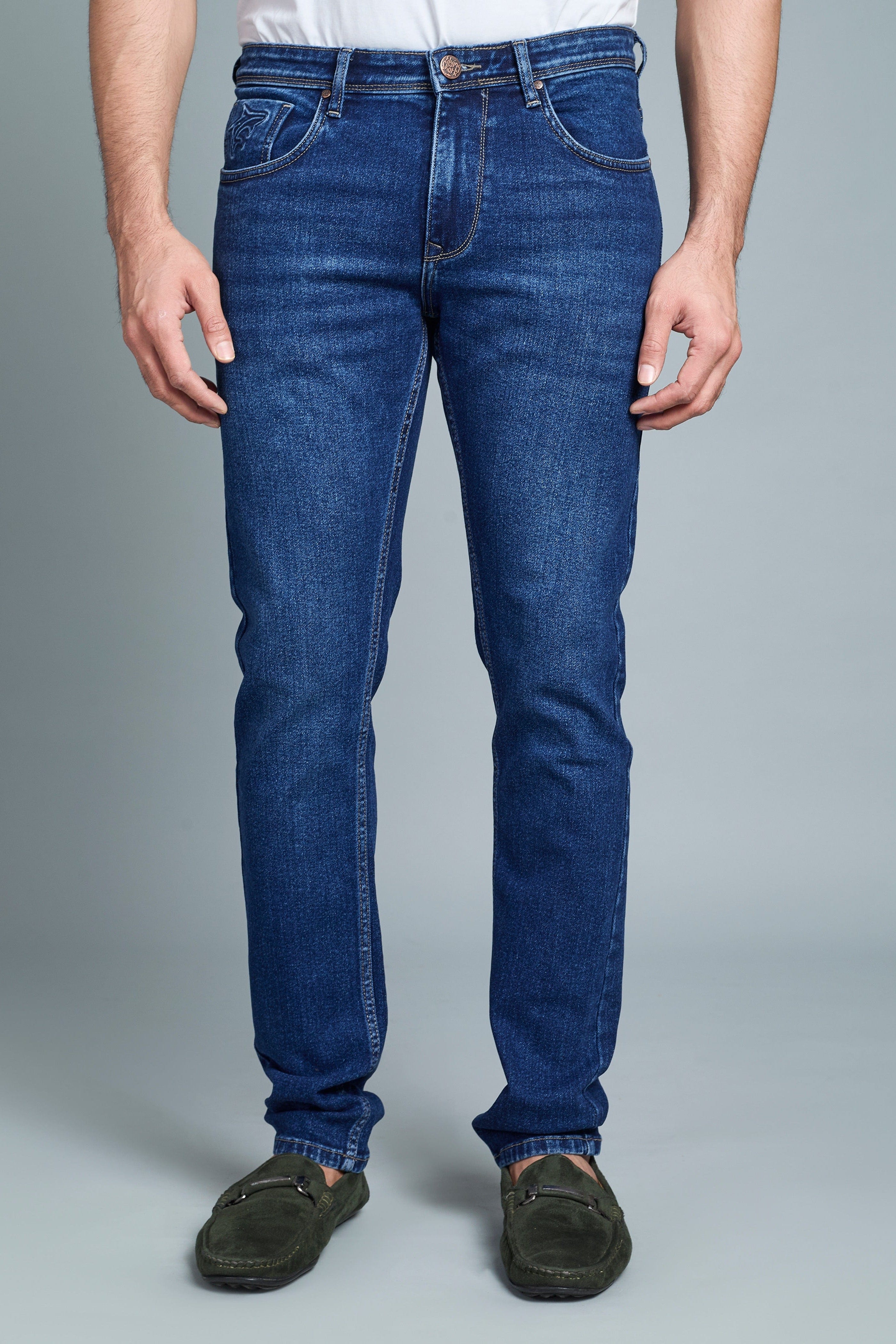 Person wearing blue jeans on a gray background