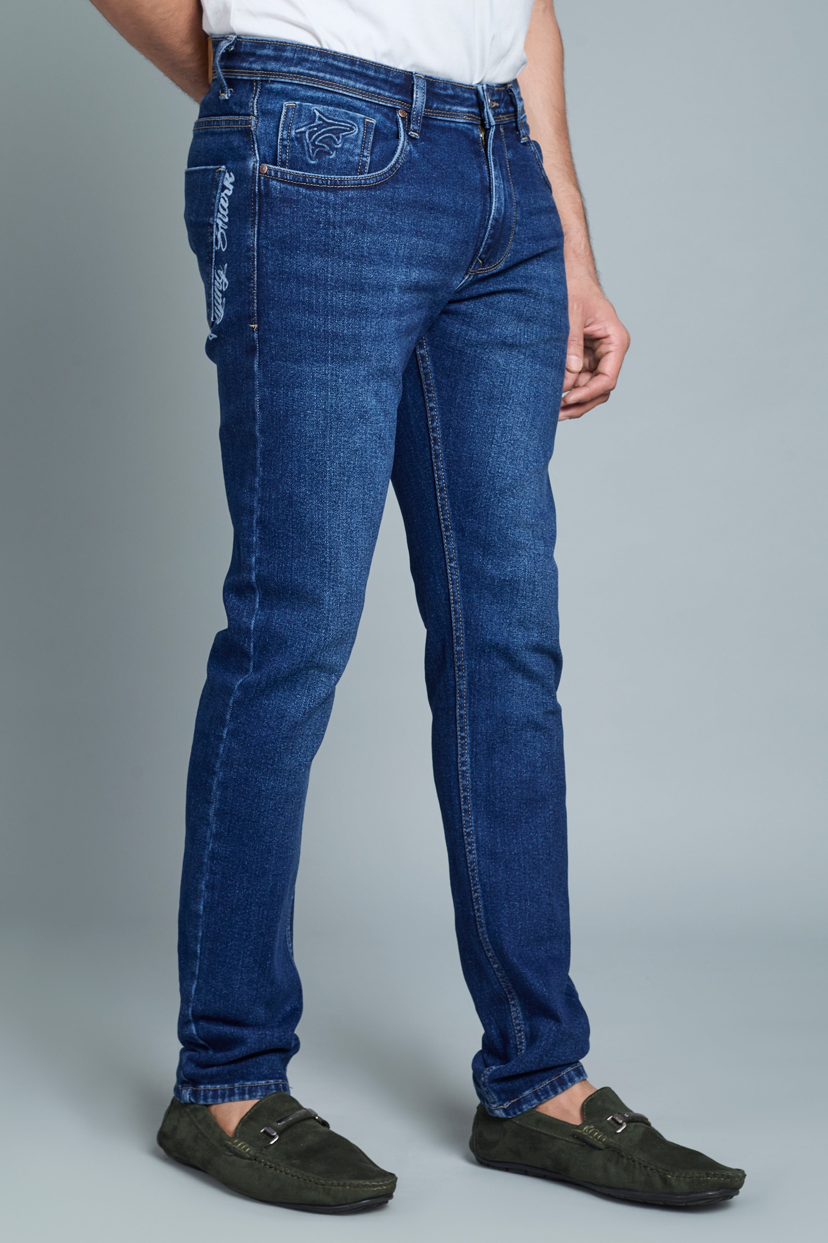Person wearing blue jeans on a gray background
