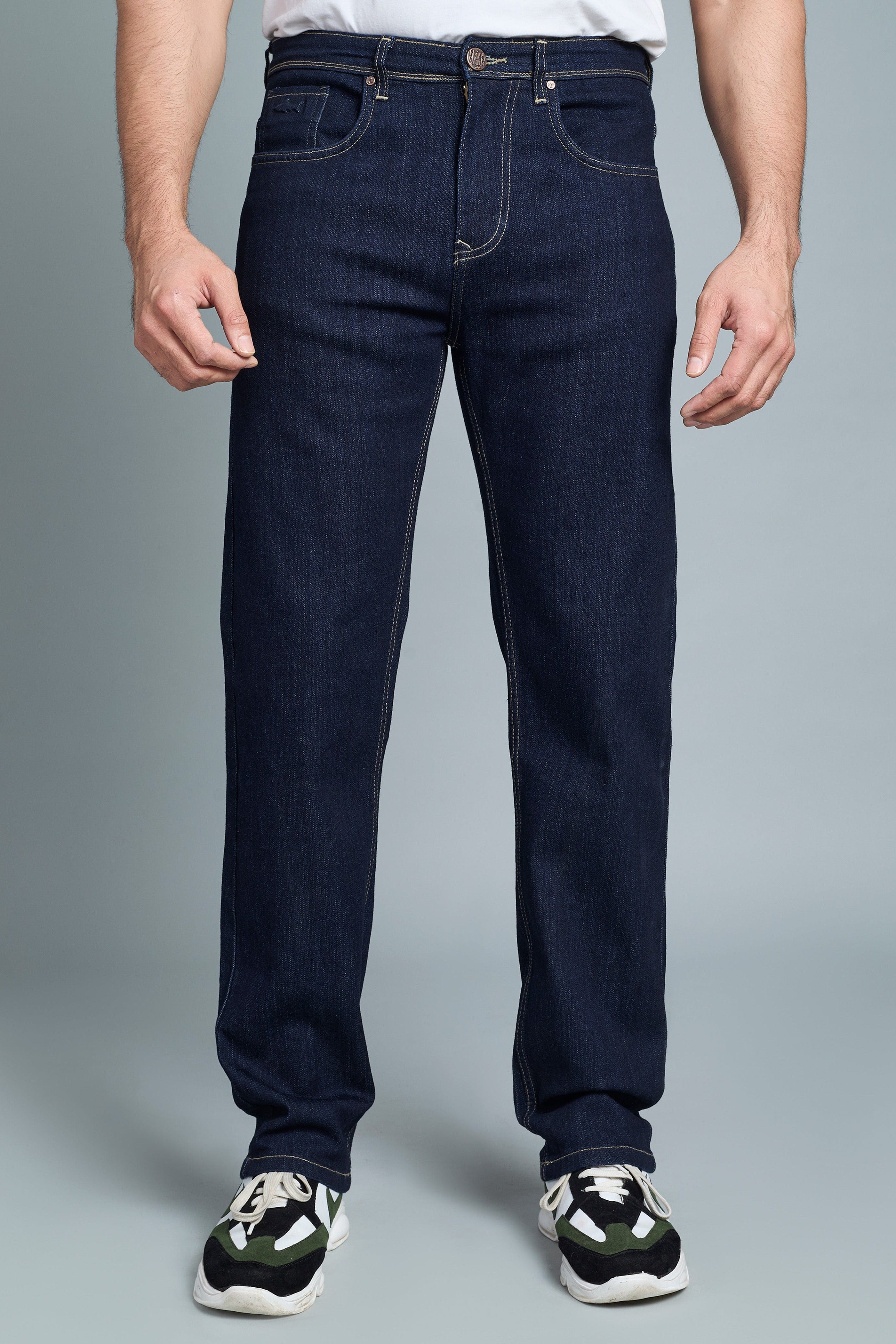 Person wearing dark blue jeans on a gray background