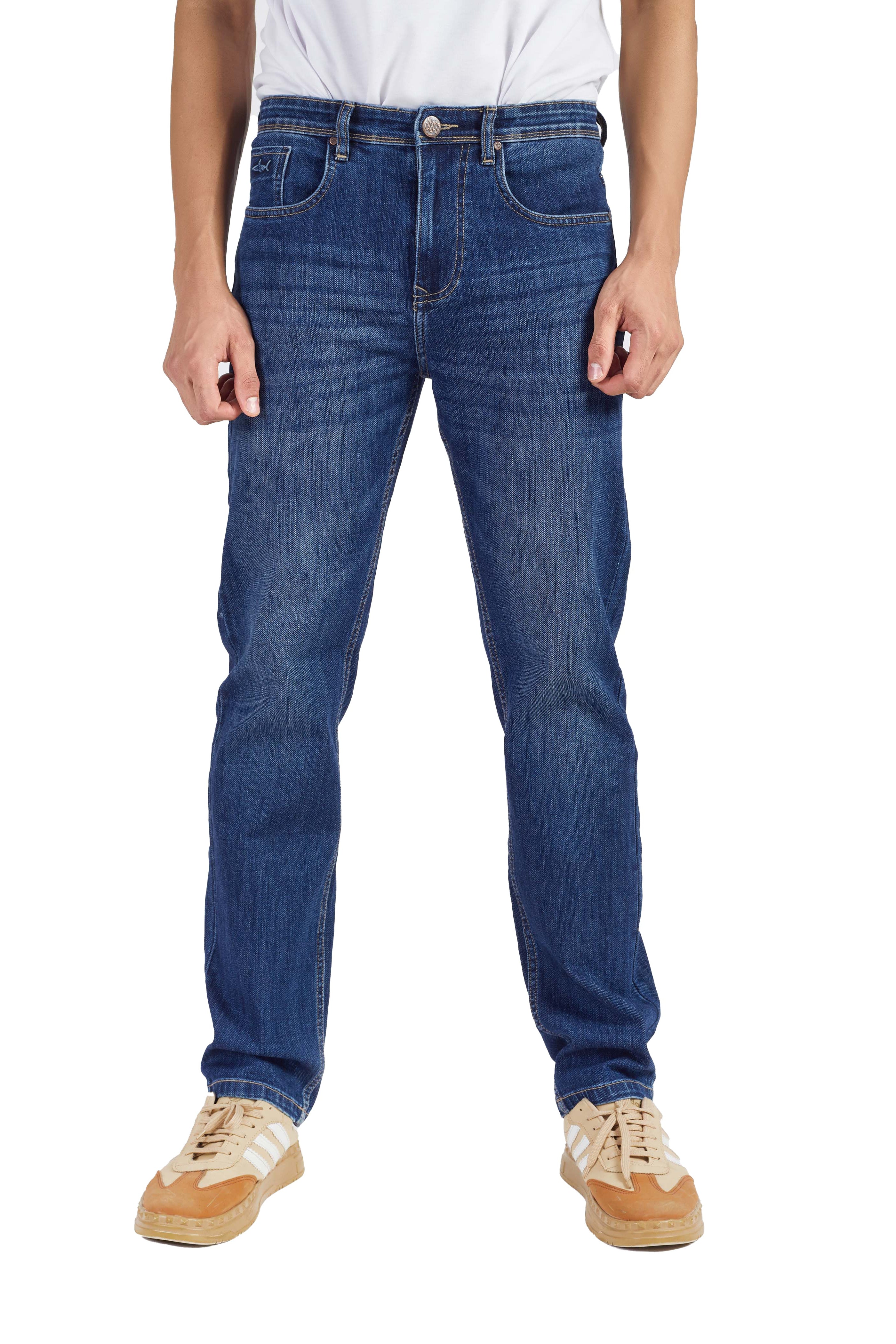 Person wearing blue jeans and beige shoes on a white background