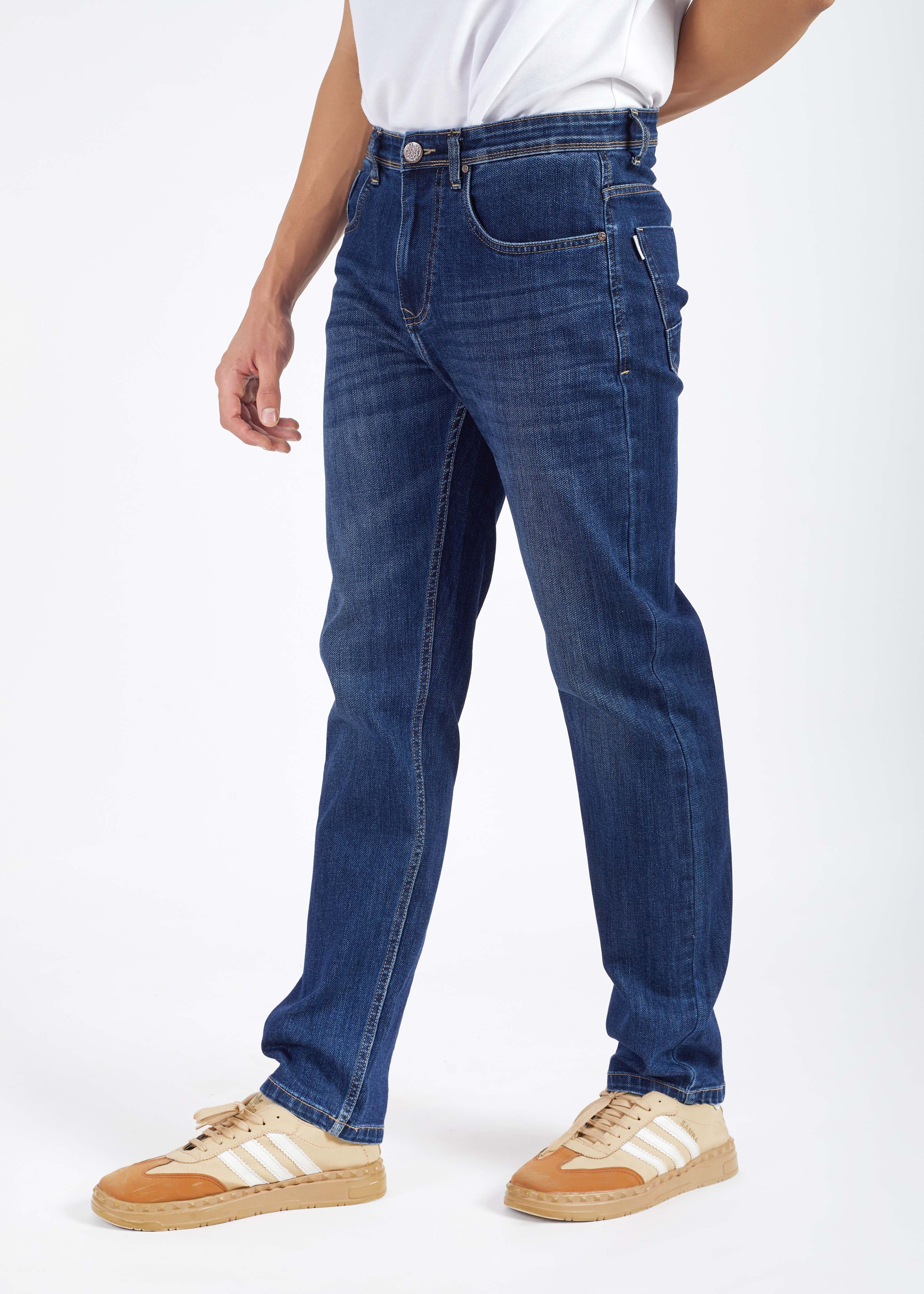 Person wearing blue jeans and white sneakers on a white background